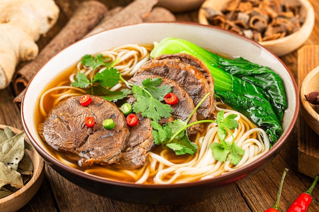 spicy red soup beef noodle in a bowl on wooden table