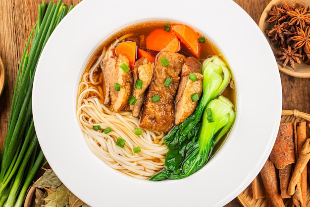 Spicy red soup beef noodle in a bowl on wooden table