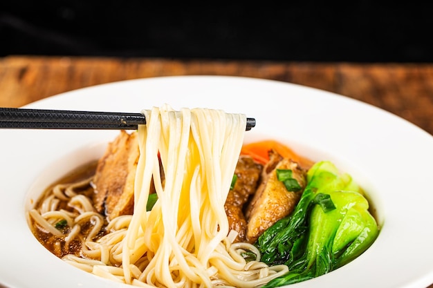 Spicy red soup beef noodle in a bowl on wooden table