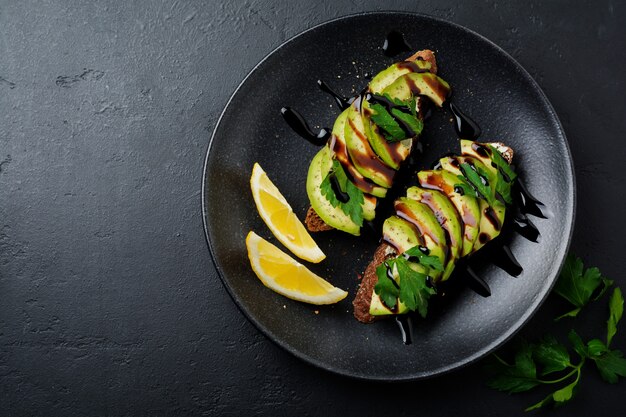 Spicy rye toasts with avocado and lemon and balsamic sauce