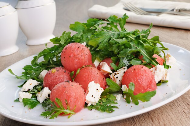 Spicy salad of watermelon balls with arugula and slices of feta