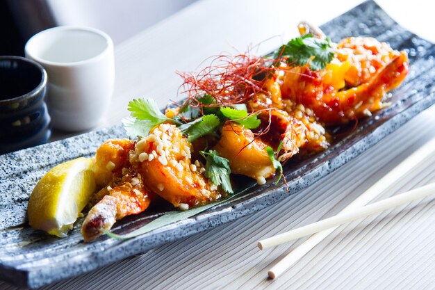 Foto gamberi piccanti con salsa giapponese. piatto di pesce in un elegante ristorante giapponese.