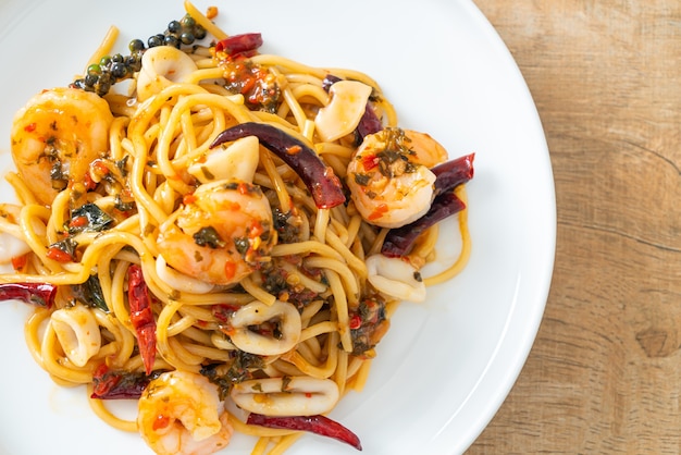 Foto spaghetti piccanti ai frutti di mare - spaghetti saltati con gamberi, calamari e peperoncino