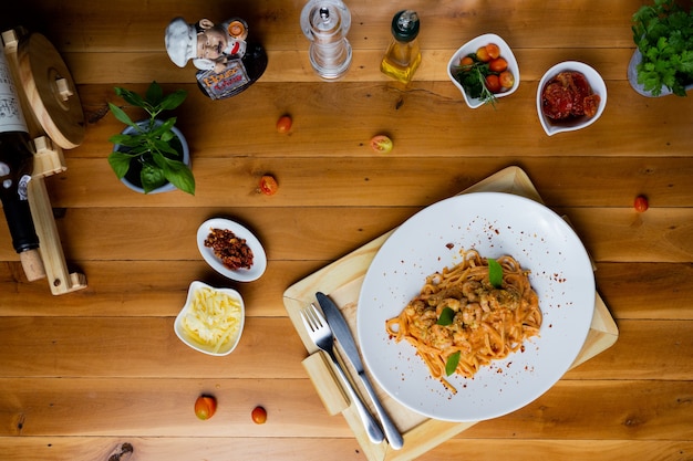 Острые спагетти с креветками в томатном соусе на тарелке.
