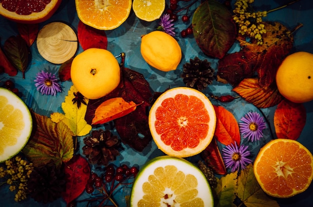 Photo spicy spices with different citrus fruits and nuts on an old wooden background