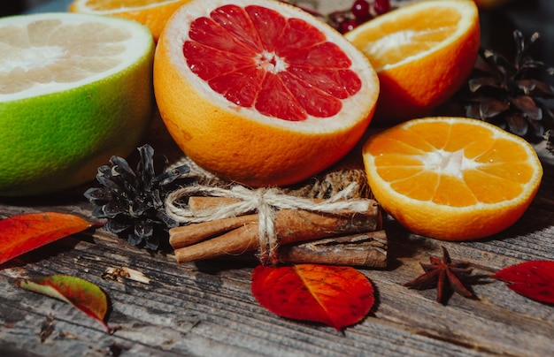 Spicy spices with different citrus fruits and nuts on an old wooden background