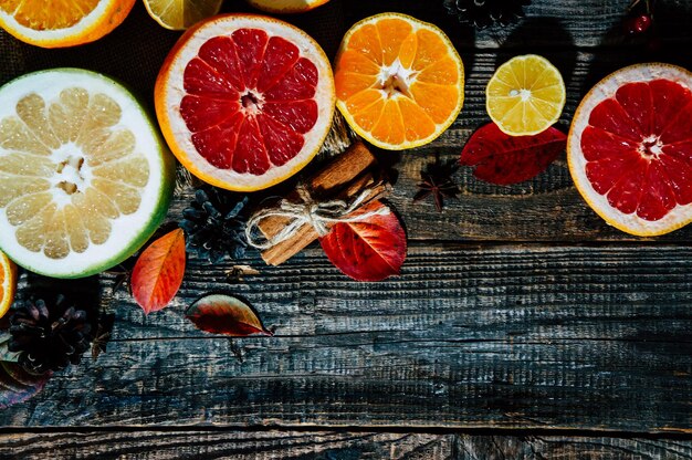 Photo spicy spices with different citrus fruits and nuts on an old wooden background