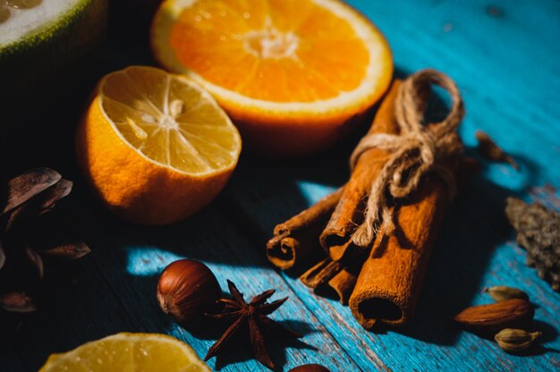 Spicy spices with different citrus fruits and nuts on an old wooden background