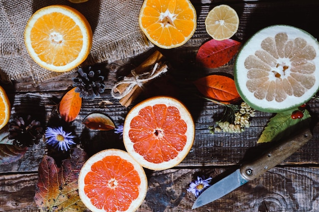 Spicy spices with different citrus fruits and nuts on an old wooden background