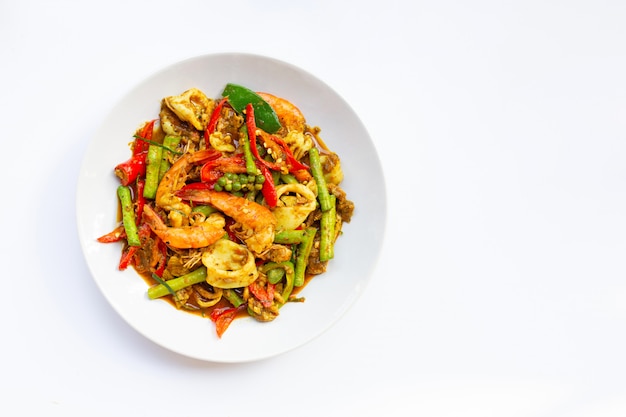 Spicy stir fried shimp, squid and pork with Thai Southern chili paste and longbean on white background.