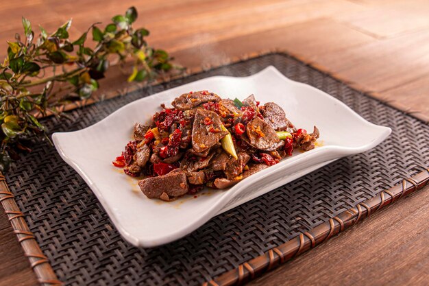 Spicy Stirfried Pork Liver served dish isolated on wooden table top view of Hong Kong food