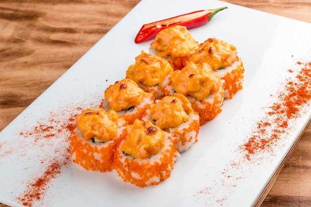 Spicy sushi roll in tobiko on white background