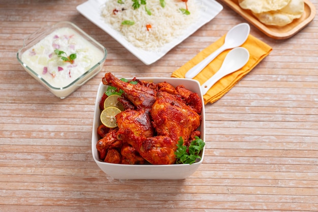 Spicy Tandoori chicken garnished with coriander leaf in square shaped white bowl