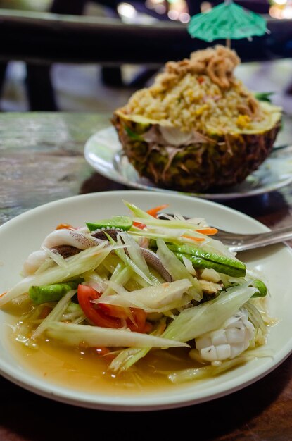 Spicy Thai salad of green papaya catfish there with seafood