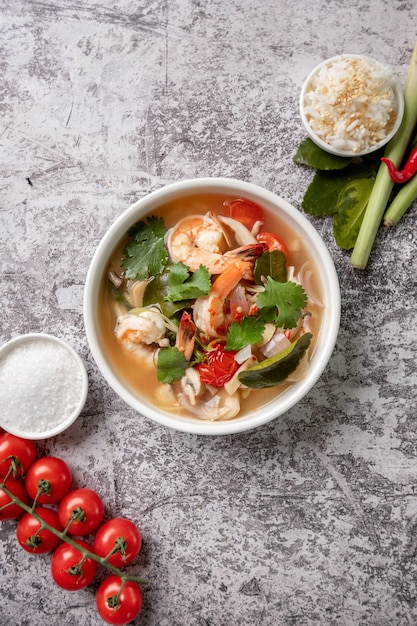 Photo spicy tom yam kung, tom yum sour soup with shrimp, prawn, coconut milk, lemongrass and chili pepper in a bowl