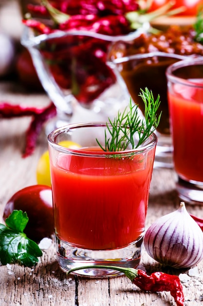 Spicy tomato juice with vegetables on a vintage wooden background selective focus