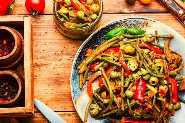 Spicy vegetable appetizer made from pepper, asparagus beans, tomato and capers