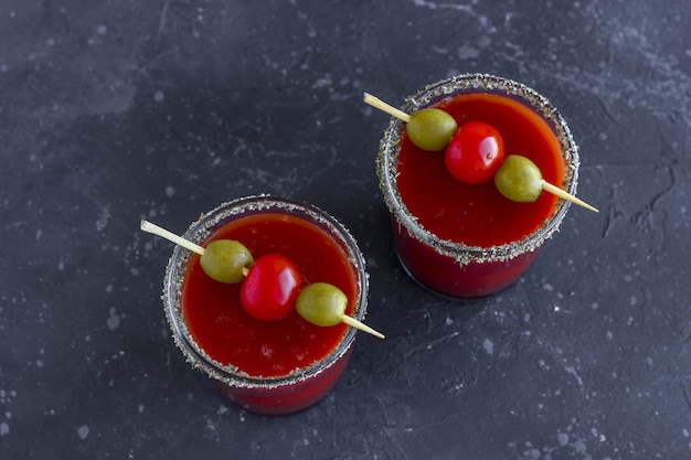 Spicy Vodka Bloody Mary cocktails served with pickled veggies (tomatos, olive and celery).