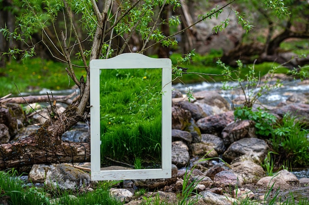 Spiegel in een oud kader op de stenen door de stromende close-up van de de huwelijksdecoratie van de rivier