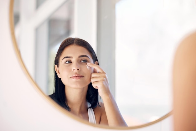 Spiegelreflectie van vrouw met huidverzorgingscrème spa-lotion of dermatologiezalf voor melasma- of acnebehandeling Badkamer gezichtsroutine gezondheidszorg en gezicht van meisje cosmetica schoonheidsproduct aanbrengen