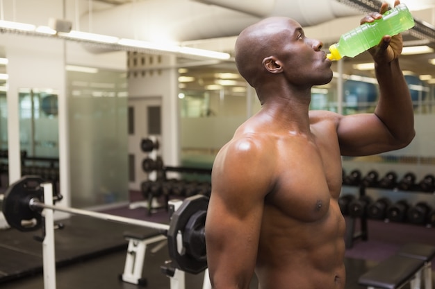 Spiermens het drinken energiedrank in gymnastiek