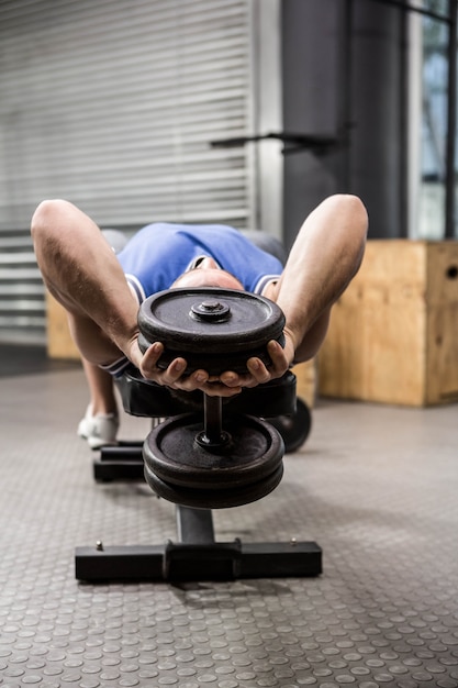 Foto spiermens op bank opheffende domoor bij de crossfitgymnastiek