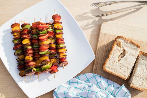 Spiesjes met worst en groenten op het tafelblad bekijken barbecue concept