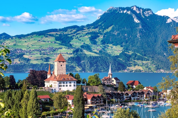 Spiez kerk en kasteel aan de oever van het meer van Thun met jachten in het Zwitserse kanton Bern, Spiez, Zwitserland.