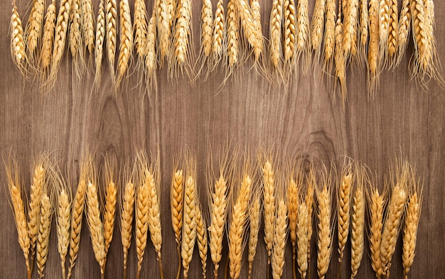 Photo spikelets of wheat on old wooden table background