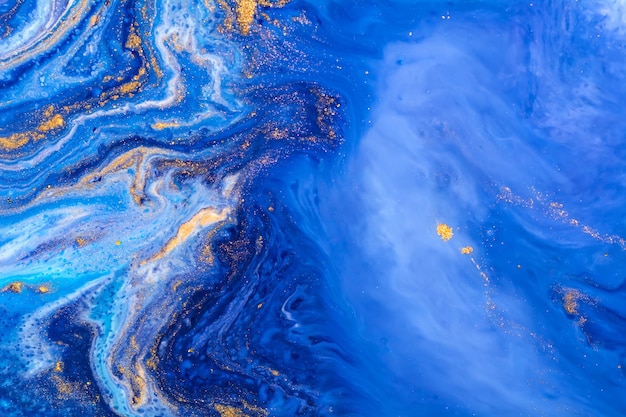 Spilled blue, white and gold acrylic paint. Liquid marble