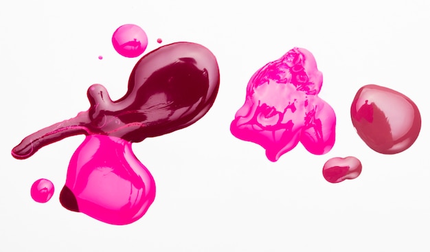 Spilled bright colorful nail polish with white backdrop