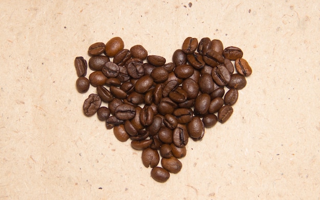 こぼれたコーヒー豆。ハートの形のコーヒー。包装紙