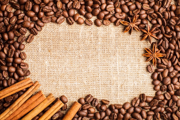 Spilled coffee beans frame with cinnamon and anise