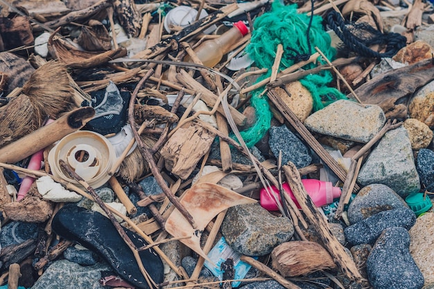 Spilled garbage on sea shore stones gray gravel empty used\
dirty waste plastic bottles environmental total pollution\
ecological problem abstract composition textured nature background\
web design