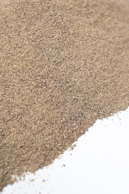 spilled ground black pepper spicy seasoning on a white background