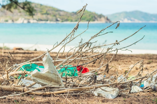 Foto immondizia di riciclaggio versata sulla spiaggia del mare di lazur rifiuti usati schiuma bianca e sacchetti di plastica inquinamento totale ambientale problema ecologico riscaldamento globale alla gente non interessa