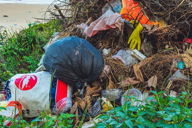 Spilled recycling man made garbage in park forest near city Empty used dirty waste plastic bottles caps bags and carton paper boxes Environmental total pollution ecological problem global warming