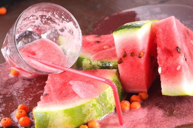 Spilled watermelon cocktail with watermelon slices on dark background Healthy food concept sweet summer dessert Closeup