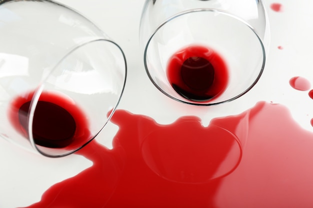 Spilled wine from glasses on white table