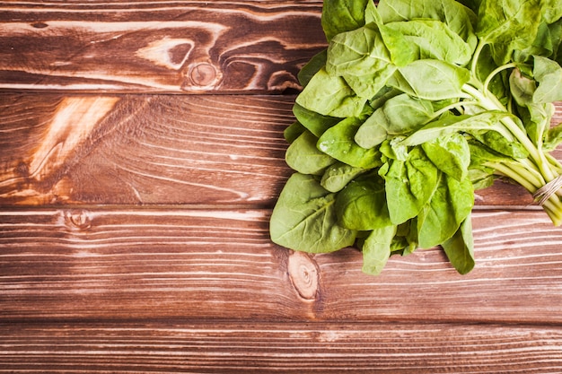 Spinach bunch on the wooden table with copy space