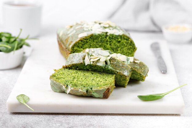 Spinach cake with Flaked almonds cutted on marble board Sponge pie Grey background Green texture