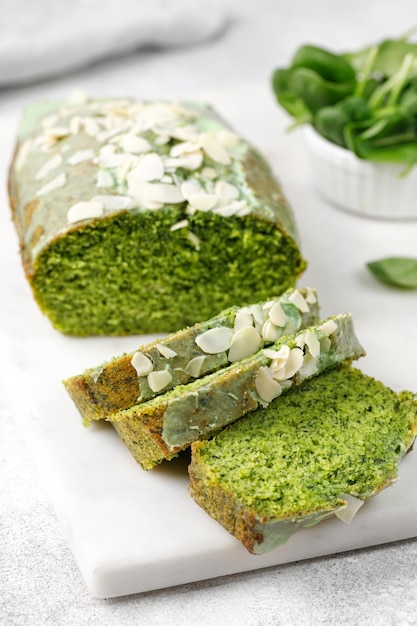 Spinach cake with spinach and Flaked almonds cutted on marble board Grey background