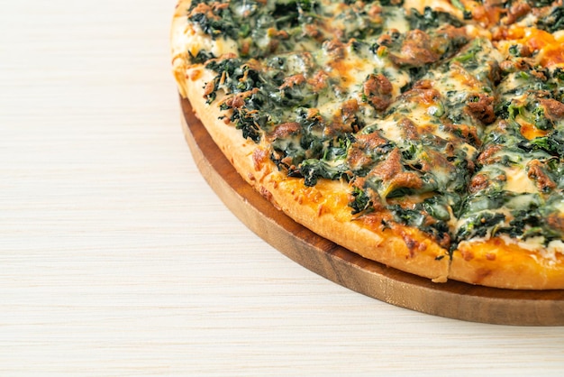 Spinach and cheese pizza on wood tray