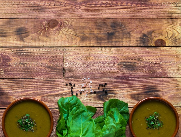 Spinach cream soup with asparagus, on wooden background