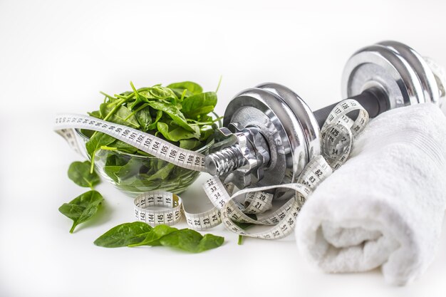 Spinach dumbbells and measure tape isolated on white background.