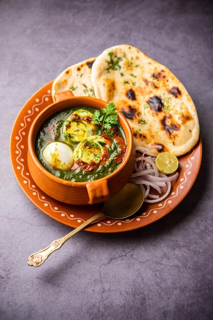 Photo spinach egg curry is an indian non vegetarian dish made using palak gravy with eggs