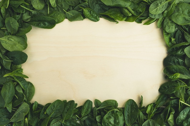 Spinach leaves and empty cutting board. Food background, healthy diet