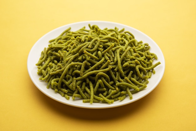 Spinach or palak sev are crunchy fried savory noodles. Homemade Thick and thin green shev or namkeen is a classic Indian snack