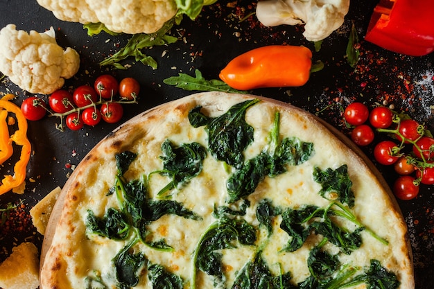 Foto pizza agli spinaci per vegetariani. stile di vita vegano di nutrizione sana. piatto italiano fatto in casa