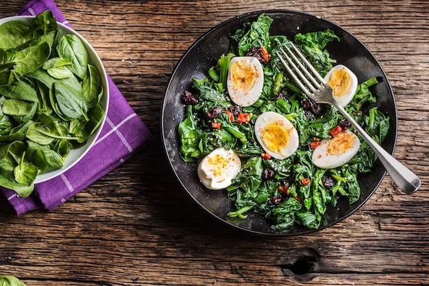 Spinach Salad. Fresh spinach salad with eggs chili pepper and sweet cranberries.